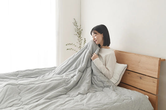 女性が肌に毛布をあてている画像
